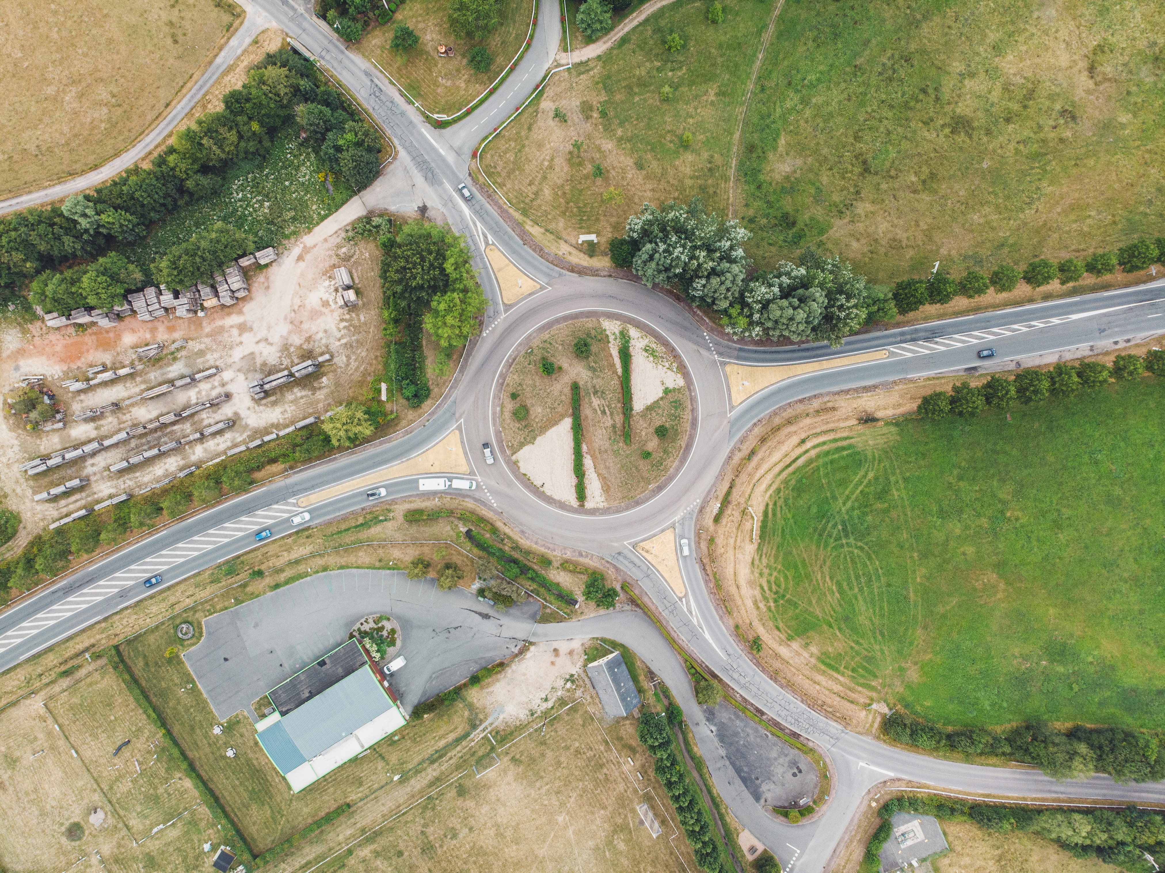 An aerial view of a rural roundabout surrounded by farmland, representative of the rural highway conversions in Kansas's program